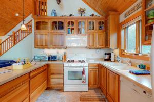 a kitchen with wooden cabinets and a white stove top oven at Shangri La in Eagle River +27 photos