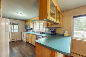 a kitchen with wooden cabinets and a blue counter top at Wild Bear Retreat in Saint Germain +14 photos