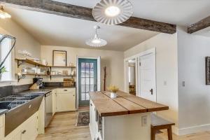 a kitchen with white cabinets and a wooden counter top at Cozy Villager in Stowe