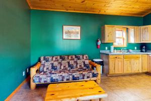 a living room with a couch and a kitchen at Gateway Lodge in Mercer