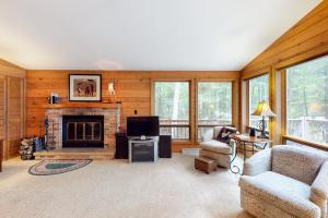 a living room with a fireplace and a tv at Chanticleer Inn: Hudson House in Eagle River