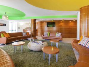 a living room with couches and tables and a tv at Ibis Styles Bari Giovinazzo in Giovinazzo