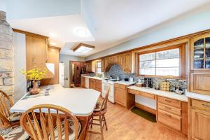 a kitchen with wooden cabinets and a table and chairs at Bayside Secret in Phelps +40 photos