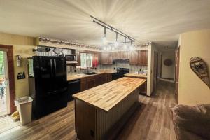 a kitchen with a black refrigerator and wooden cabinets at Northwoods Paradise in Eagle River