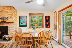 a dining room with a table and chairs and a fireplace at Northwoods Paradise in Eagle River
