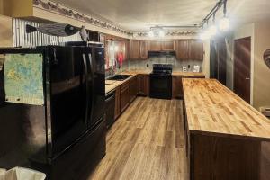 a kitchen with a black refrigerator and wooden floors at Northwoods Paradise in Eagle River