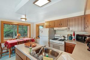 a kitchen with a sink and a stove top oven at Hotter's Cabin in Eagle River +16 photos