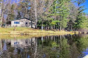 a house sitting on the side of a lake at Hotter's Cabin in Eagle River