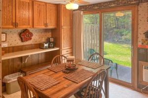 a kitchen with a wooden table with chairs and a window at Cleerwood Village #261 in Eagle River