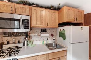 a kitchen with wooden cabinets and a white refrigerator at Cleerwood Village #261 in Eagle River +22 photos
