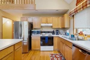 a kitchen with wooden cabinets and stainless steel appliances at Nekoosa Holiday in New Rome +12 photos