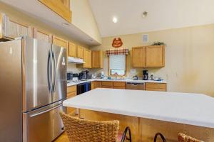 a kitchen with a stainless steel refrigerator and wooden cabinets at Nekoosa Holiday in New Rome