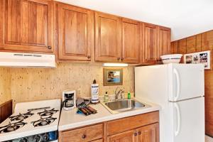 a kitchen with a white refrigerator and a sink at Cleerwood Village #252 in Eagle River