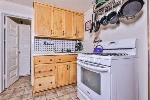 a kitchen with a white stove and wooden cabinets at West Bay Pines in Saint Germain
