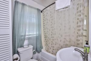 a bathroom with a toilet and a sink and a shower at West Bay Pines in Saint Germain