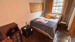 a small bedroom with a bed and a window at Hospedagem Rancho Fundo in Diamantina