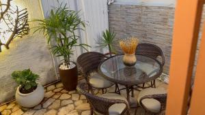 a patio with a glass table and chairs and plants at Hospedagem Rancho Fundo in Diamantina
