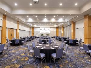 a conference room with tables and chairs and a screen at Novotel Surfers Paradise in Gold Coast +146 photos