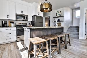a kitchen with white cabinets and a table with stools at The Studio in Minocqua +11 photos