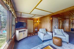 a living room with two chairs and a flat screen tv at Catfish Cottage A in Eagle River