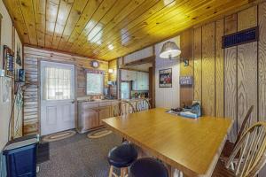 a kitchen with a large wooden table and chairs at Catfish Cottage A in Eagle River +30 photos