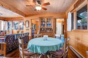 a dining room with a table and a ceiling fan at Bucky's PineIsle Retreat in Three Lakes