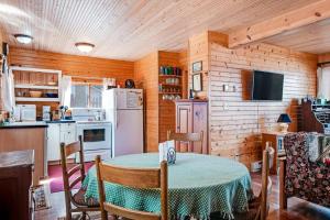 a kitchen and dining room with a table and a refrigerator at Bucky's PineIsle Retreat in Three Lakes