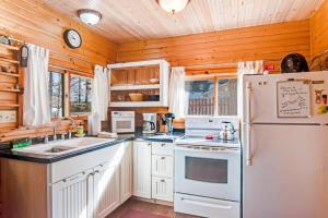 a kitchen with white appliances and a white refrigerator at Bucky's PineIsle Retreat in Three Lakes +20 photos