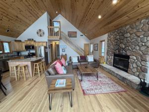 a living room with a couch and a stone fireplace at Sandy Cove in Saint Germain