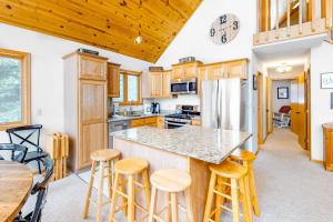 a kitchen with wooden cabinets and a island with bar stools at Sandy Cove in Saint Germain +33 photos