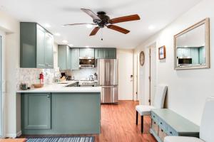 a kitchen with green cabinets and a ceiling fan at Cove View in Minocqua