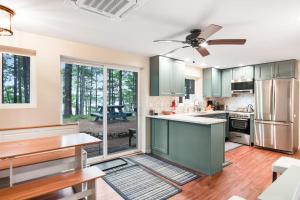 a kitchen with green cabinets and a ceiling fan at Cove View in Minocqua