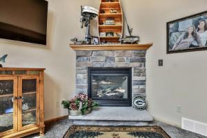 a living room with a stone fireplace and a tv at Copperwood #1 in Eagle River