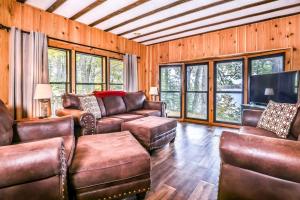 a living room with leather furniture and a flat screen tv at Tranquility Base in Rhinelander