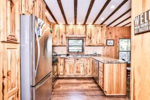 a kitchen with wooden cabinets and a stainless steel refrigerator at Tranquility Base in Rhinelander