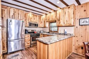 a kitchen with wooden cabinets and a stainless steel refrigerator at Tranquility Base in Rhinelander +26 photos