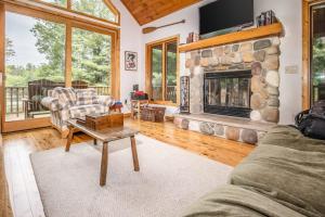 a living room with a stone fireplace and a couch at Northwoods Getaway in Arbor Vitae