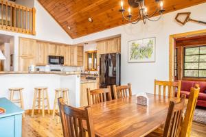 a kitchen and dining room with a wooden table and chairs at Northwoods Getaway in Arbor Vitae +42 photos