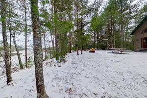 a picnic table in the snow next to a cabin at Shady Lane Lodge in Eagle River