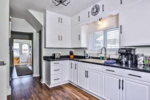 eine Küche mit weißen Schränken und schwarzen Arbeitsplatten in der Unterkunft Riverview Cottage in Eagle River + 29 Fotos