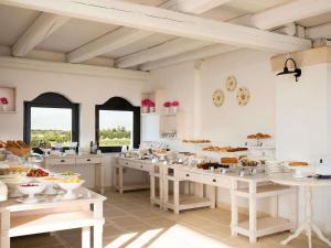 a large kitchen with a lot of food on tables at Borgobianco Resort & Spa Polignano - MGallery Collection in Polignano a Mare