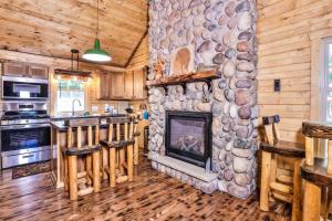 a living room with a stone fireplace in a log cabin at The Nut House in Eagle River