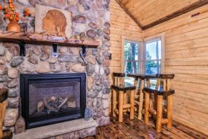 a living room with a fireplace in a log cabin at The Nut House in Eagle River +29 photos
