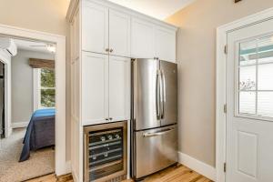 a kitchen with white cabinets and a stainless steel refrigerator at The Blue Cottage in Minocqua