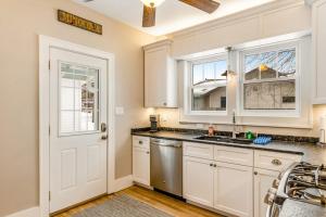 a kitchen with white cabinets and a sink and a door at The Blue Cottage in Minocqua +28 photos