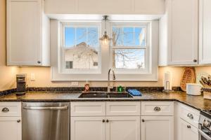a kitchen with white cabinets and a sink and a window at The Blue Cottage in Minocqua