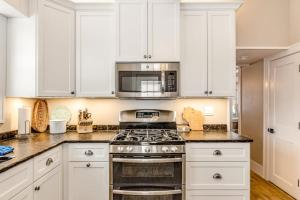 a kitchen with white cabinets and a stove top oven at The Blue Cottage in Minocqua
