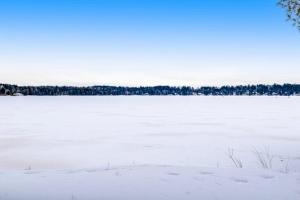 a snow covered lake with trees in the background at The Haven in Eagle River