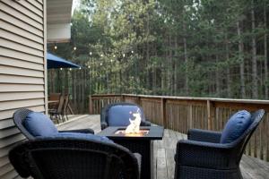 a patio with two chairs and a fire pit on a deck at Peaceful Pines in New Rome