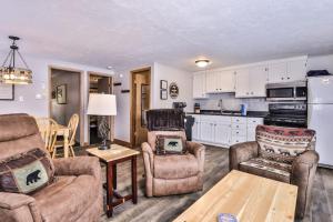a living room with two chairs and a kitchen at Our Lakeside Legacy in Saint Germain